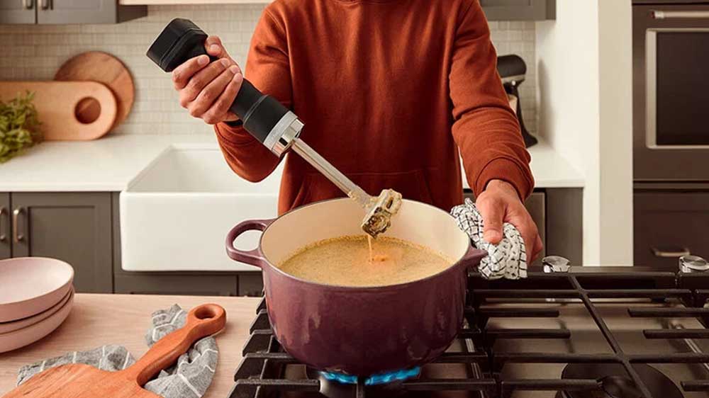 Muž používající bezdrátový tyčový mixér KitchenAid 5KHBRV00BM _02