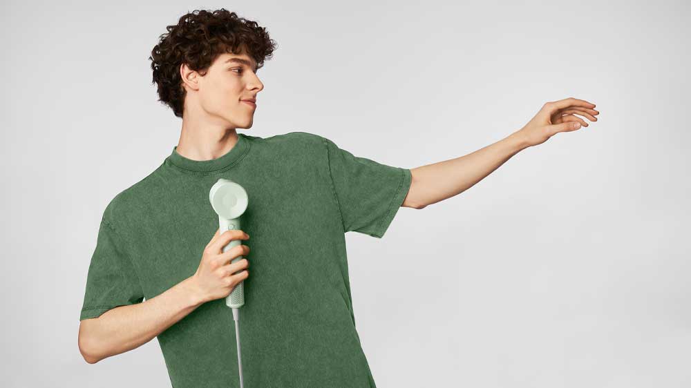 Muž držící fén v ruce_03