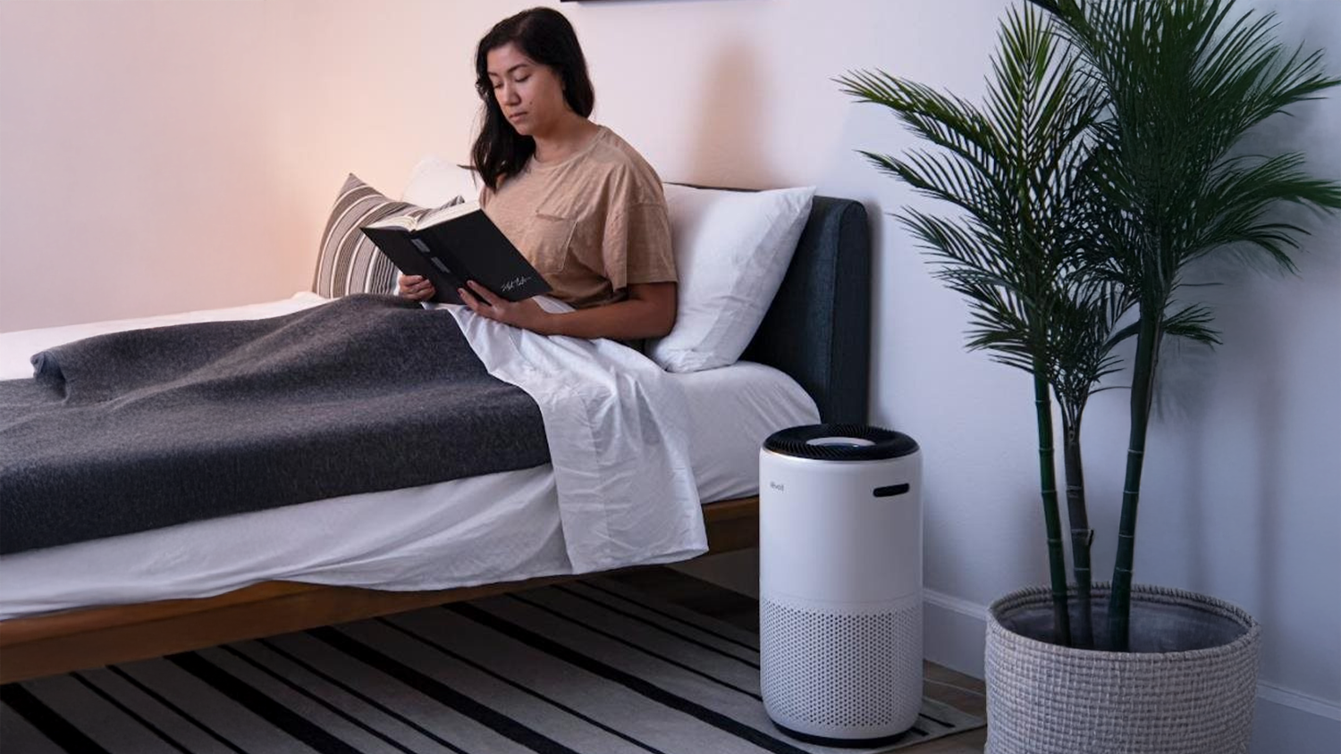 Žena si čte kn&iacute;žku, v popřed&iacute; je čistička vzduchu Levoit Core400S SMART