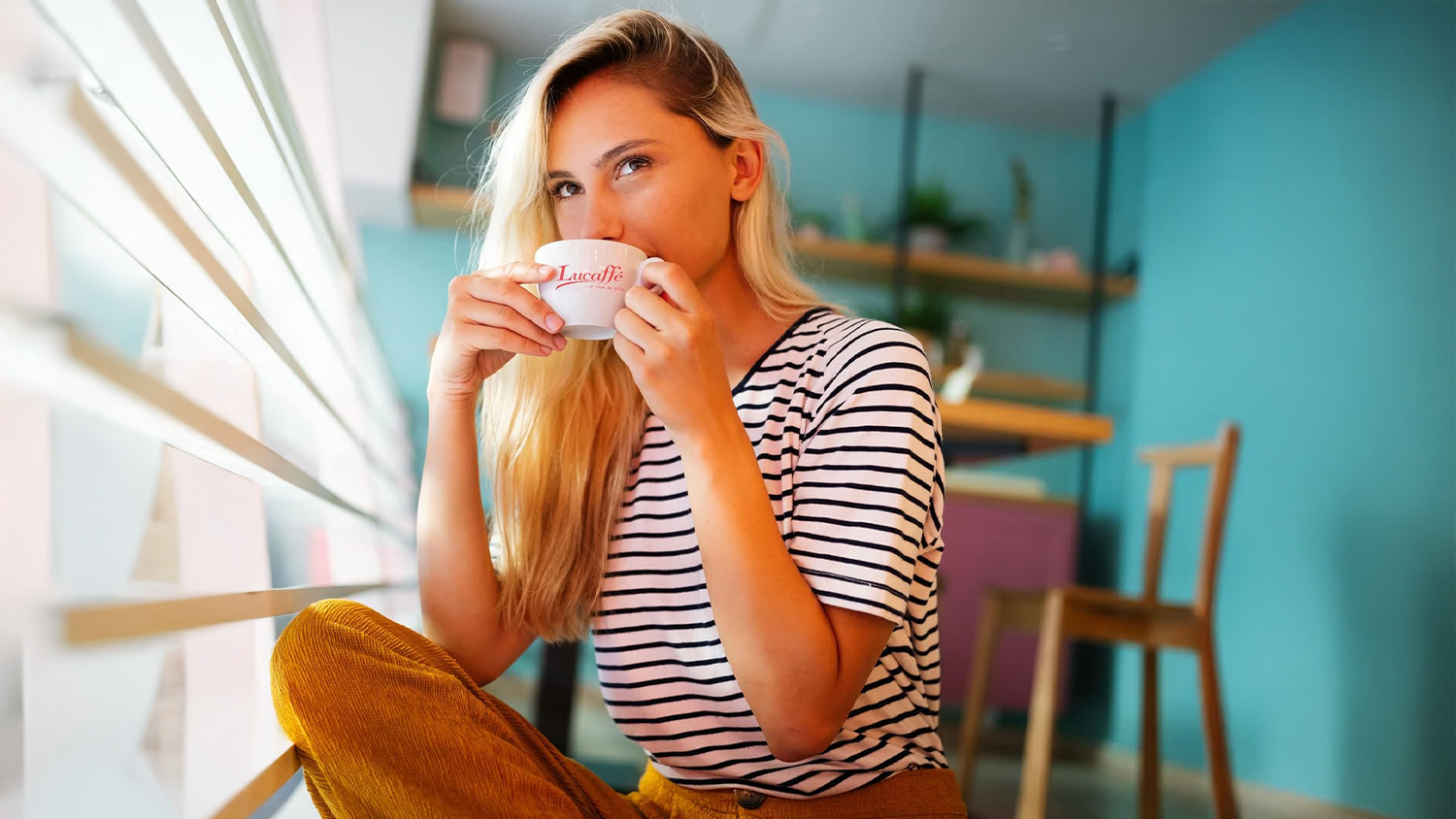 Žena pije k&aacute;vu z Lucaff&eacute; hrnečku
