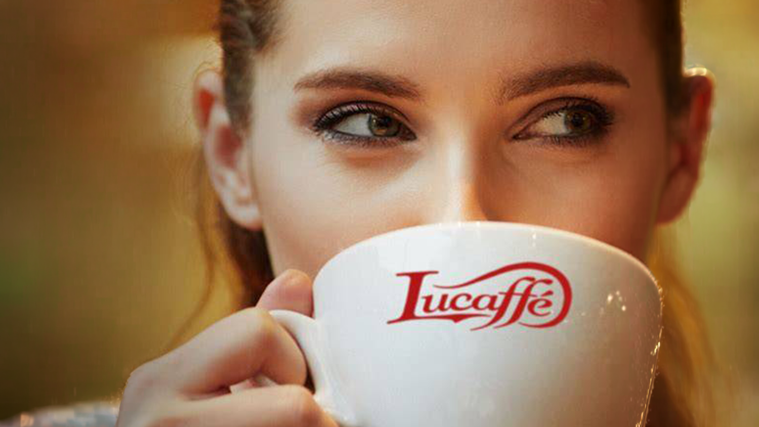 Žena pije z šálku Lucaffé