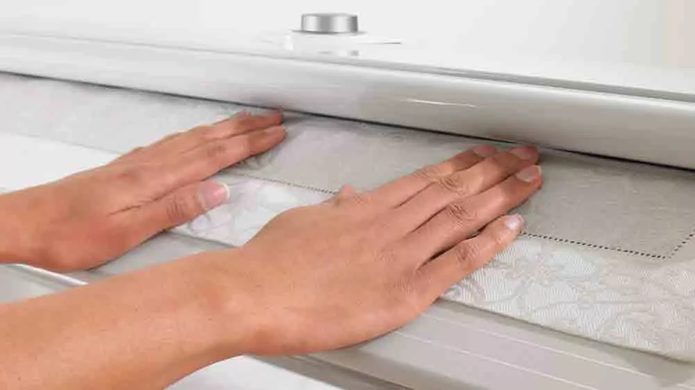 Ženské ruce přidržují prádlo v mandlu Miele B 995 D_05