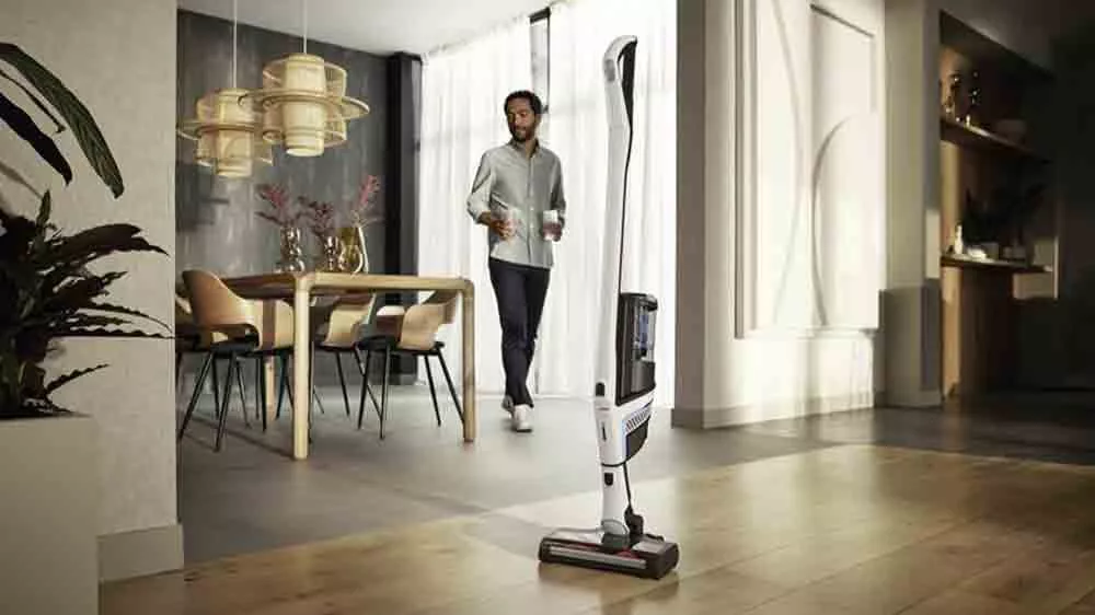 Akumulátorový vysávač Miele Triflex HX2 Blue Pulse v interiéri s mužom v pozadí_02