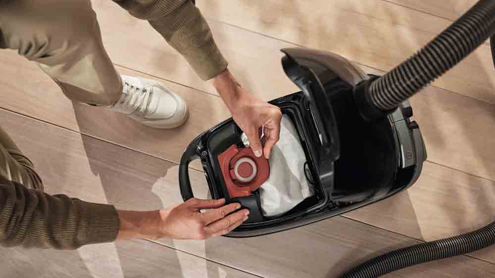 Muž vkládá prachový sáček Miele CO XL HyClean Pure do vysavače_02