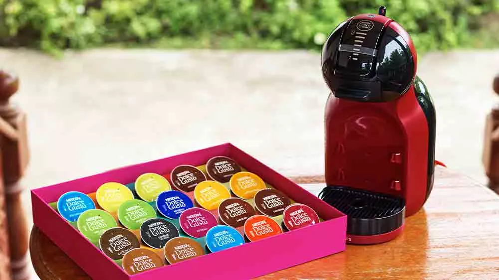 Kávovar Dolce Gusto s kapslemi na stole_02