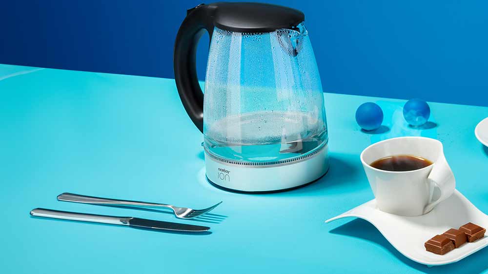 Rychlovarná konvice Niceboy ION Kettle K1 Crystal Glass postavená vedle šálku kávy_02