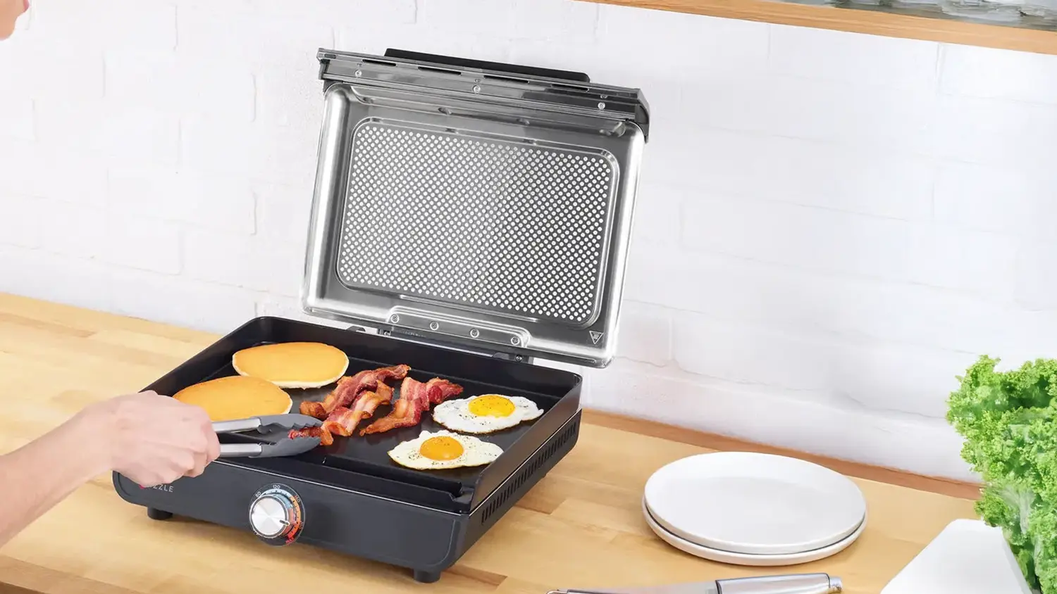 Žena připravuje snídani na grilu Ninja GR101EU Sizzle Smokeless