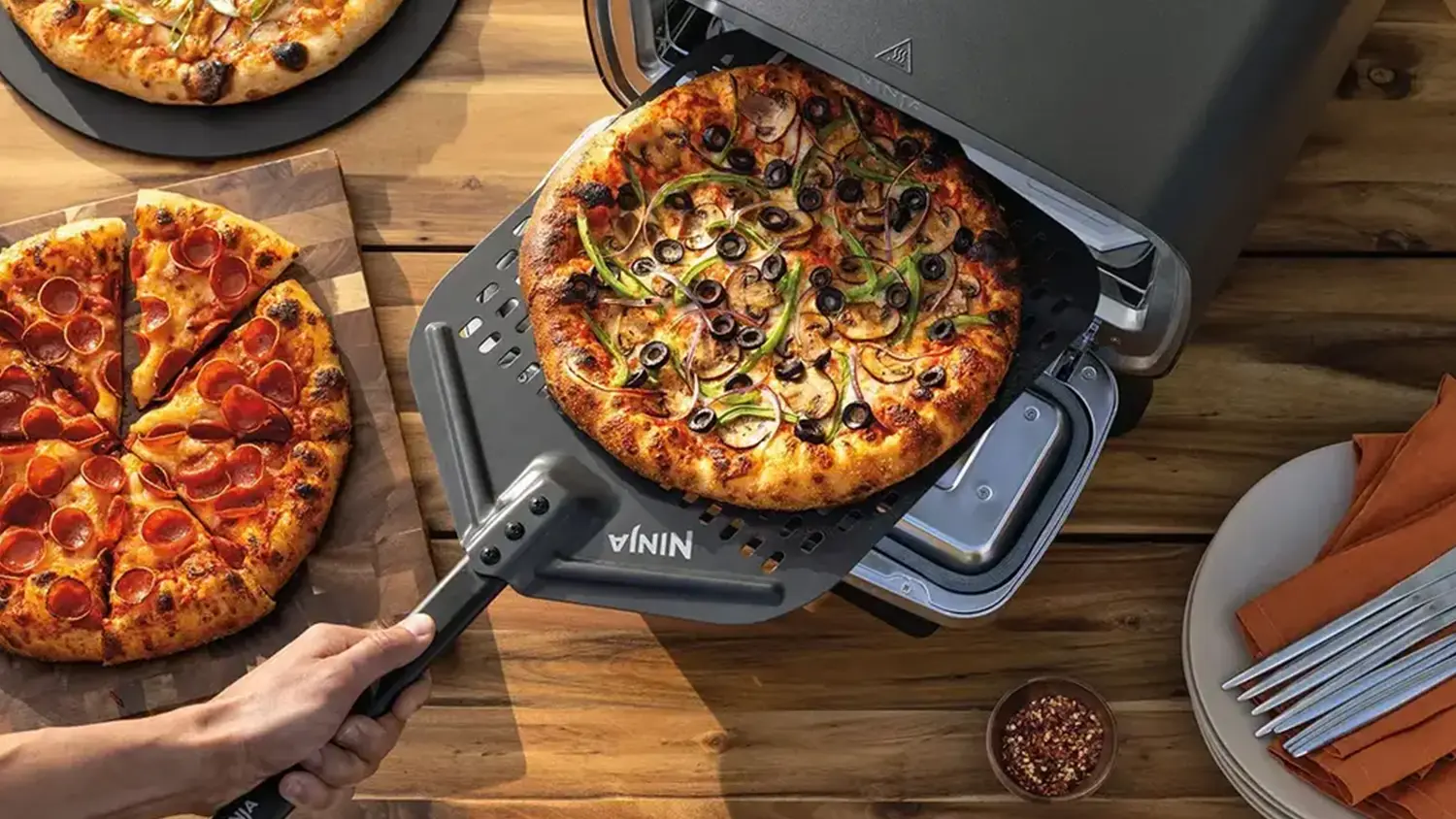 Pizza na stole a na lopatě v peci Ninja MO201EU