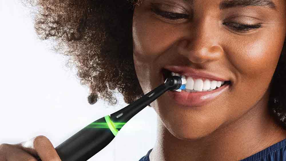 žena si čistí bílé zuby elektrickým kartáčkem_03