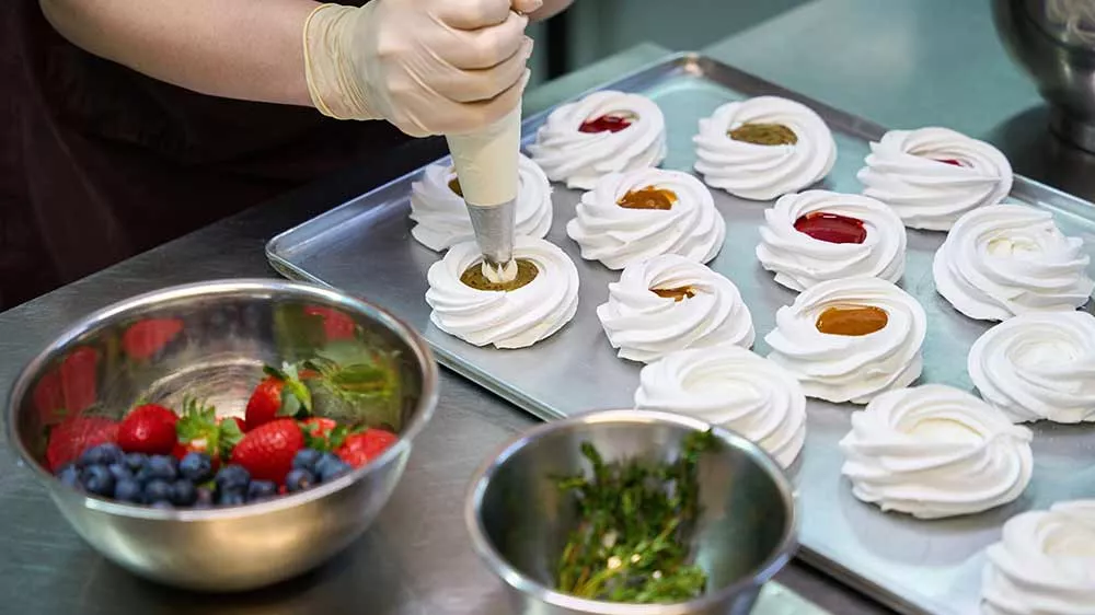 Žena připravuje dezert pavlova z vyšlehané šlehačky_02