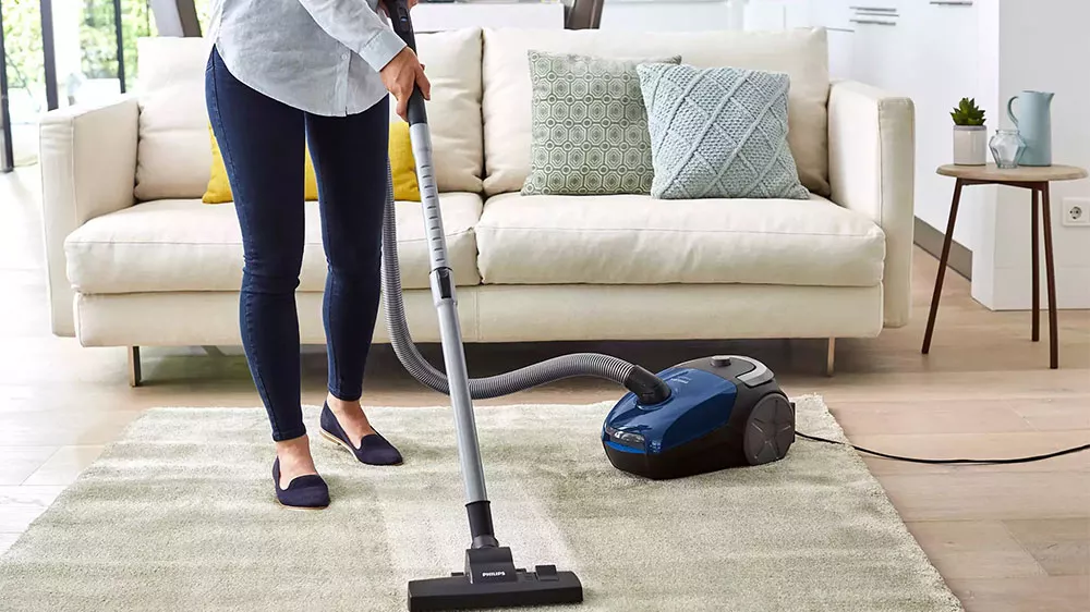Žena vys&aacute;v&aacute; s vysavačem Philips PowerGo FC8240/09_04