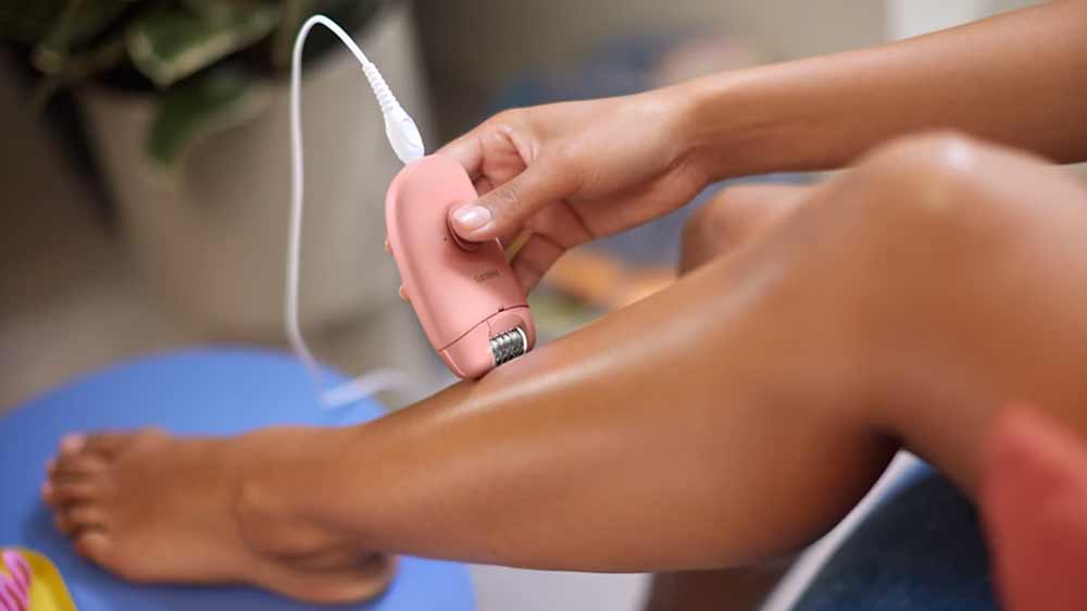 Žena si epiluje nohy dámským epilátorem Philips BRE227/00_02