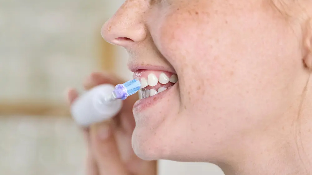 Žena si čistí zuby zubním kartáčkem s hlavicí Philips Sonicare Premium Gum Care HX9052/87_02