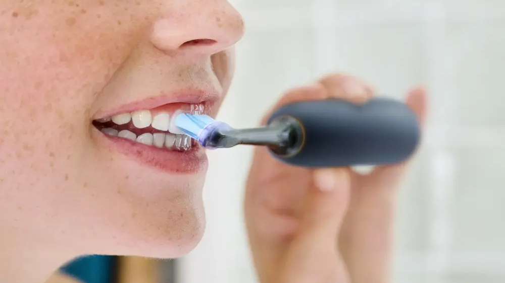 Žena si čistí zuby zubním kartáčkem s hlavicí Philips Sonicare Premium Gum Care HX9052/88_02