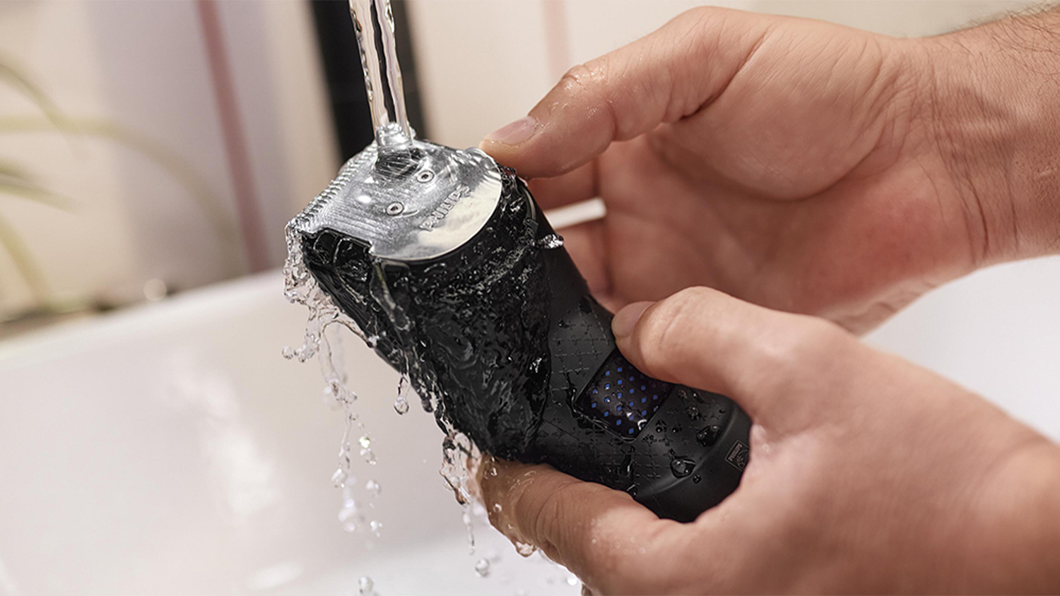 Pohľad na Zastrihávač vlasov HC7650/15 Philips Series 7000 pod tečúcou vodou.