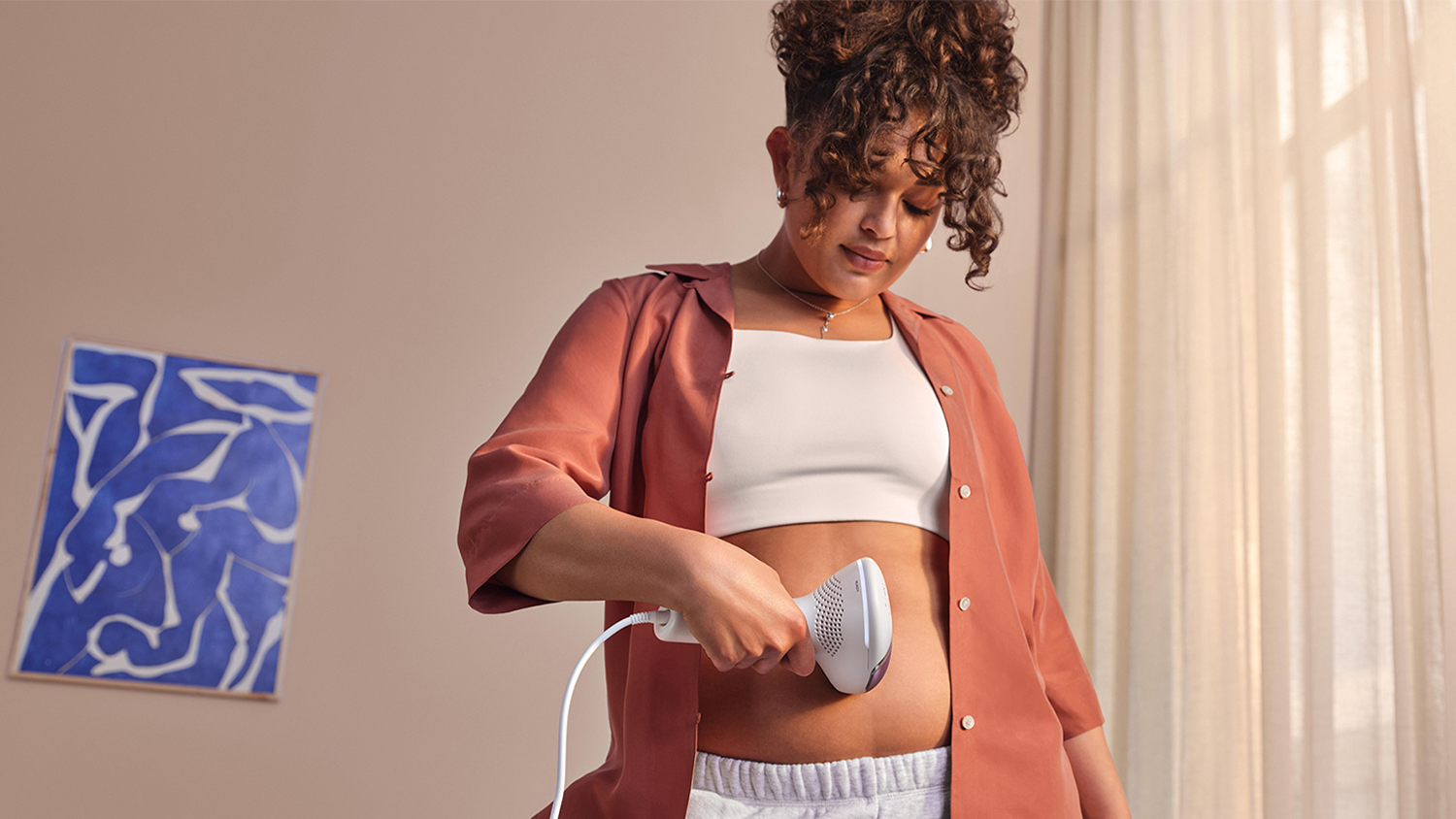 Žena použ&iacute;vaj&uacute;ca IPL epil&aacute;tor Philips Lumea IPL 8000 BRI934/00 na bruchu