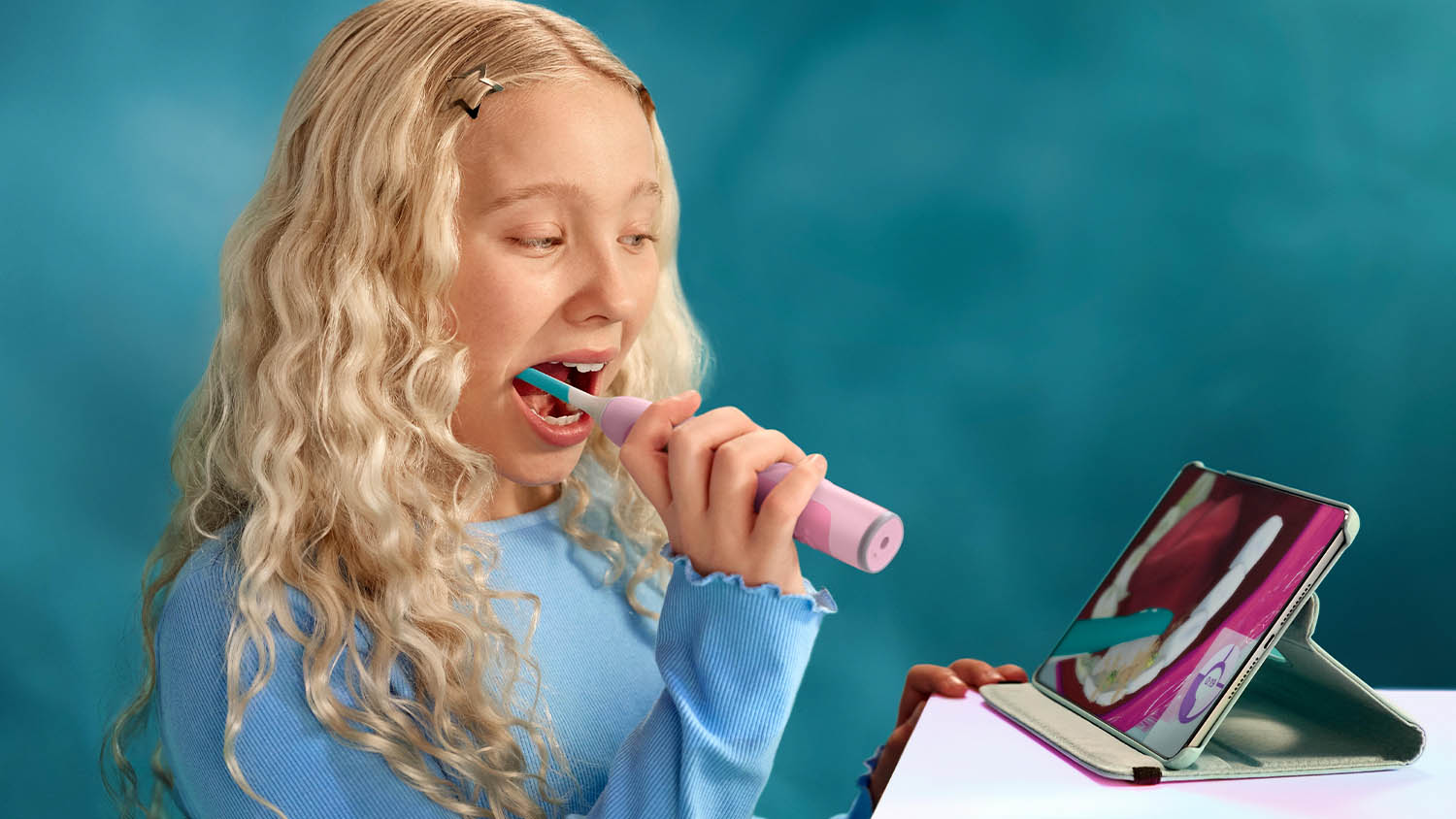 Dívka sledující přes aplikaci jak správně používat kartáček při čištění zubů