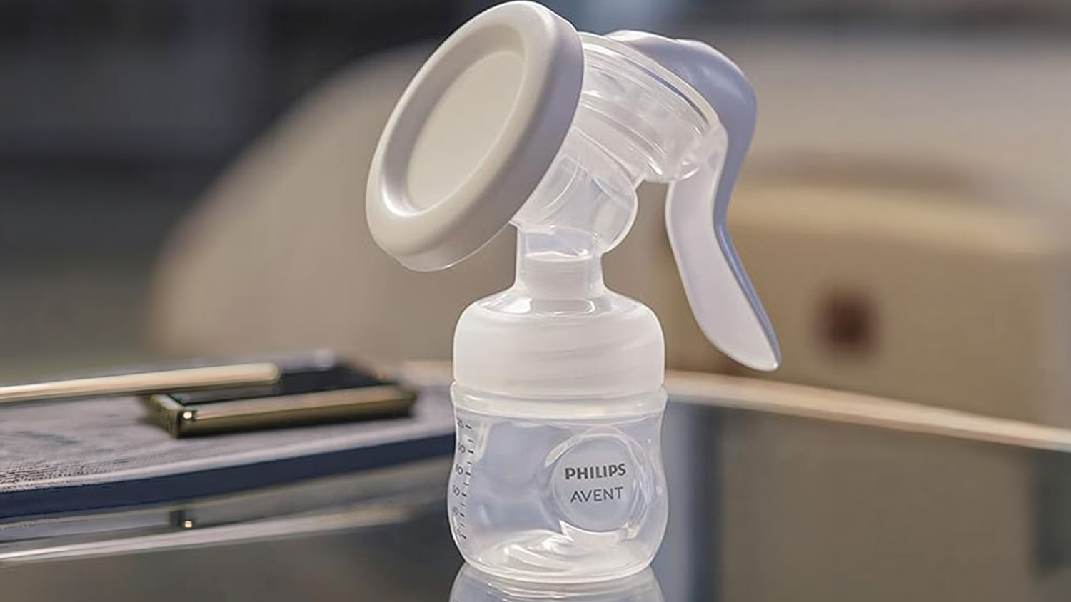 Manu&aacute;ln&iacute; ods&aacute;vačka mateřsk&eacute;ho ml&eacute;ka Philips Avent SCF430/10 položen&aacute; na stole.