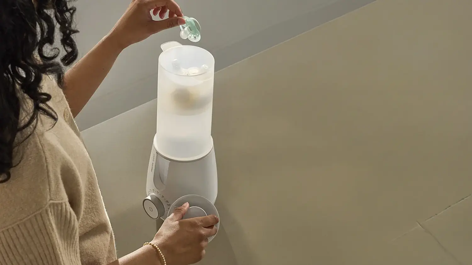 Žena, ktorá vkladá cumlík do sterilizátora.