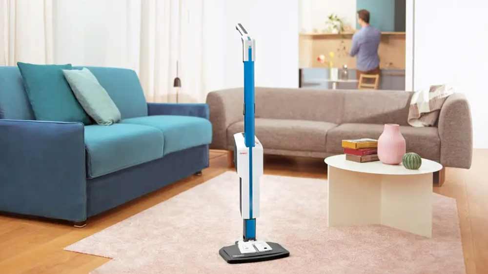 Muž čistící obklady v koupelně za použití ručního parního čističe z parního mopu Polti Vaporetto SV660_Style_03