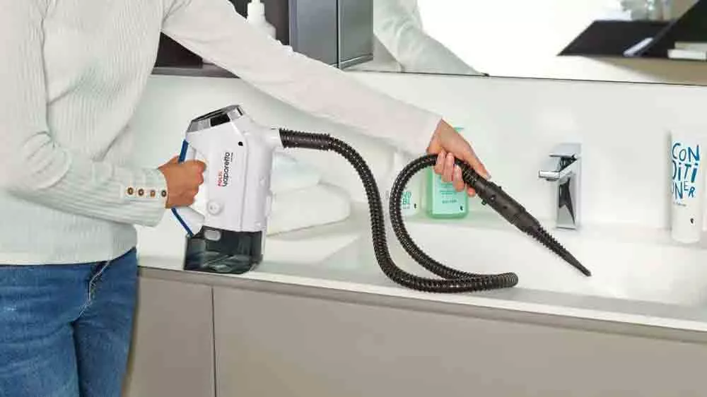 Žena při úklidu koupelny parním čističem Polti Vaporetto 3 Clean
