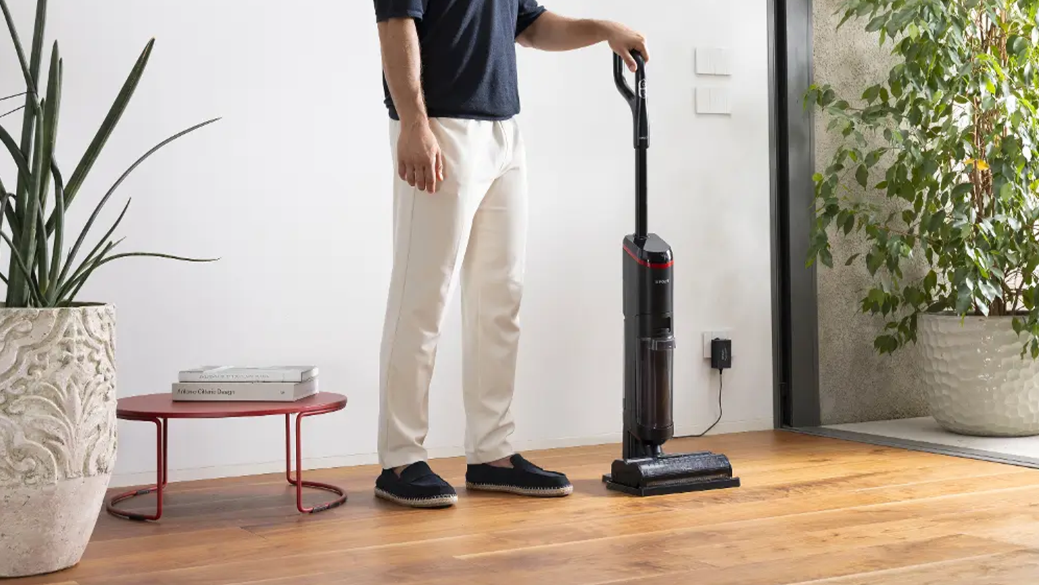 Muž stoj&iacute;c&iacute; vedle vysavače a parn&iacute;ho mopu Polti RollySteam WD40C