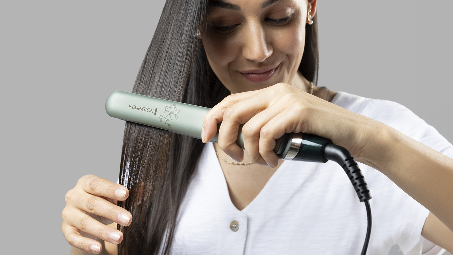 Žena si vyrovnáva vlasy žehličkou Remington Botanicals S5860