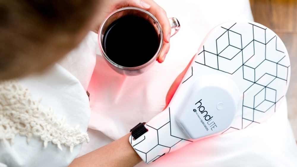 Osoba drží v jedné ruce nápoj, zatímco na druhou ruku používá světelnou masku_02