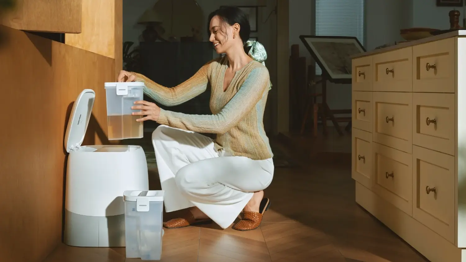 Žena u dokovací stanice robotického vysavače Roborock Qrevo 2 Pro