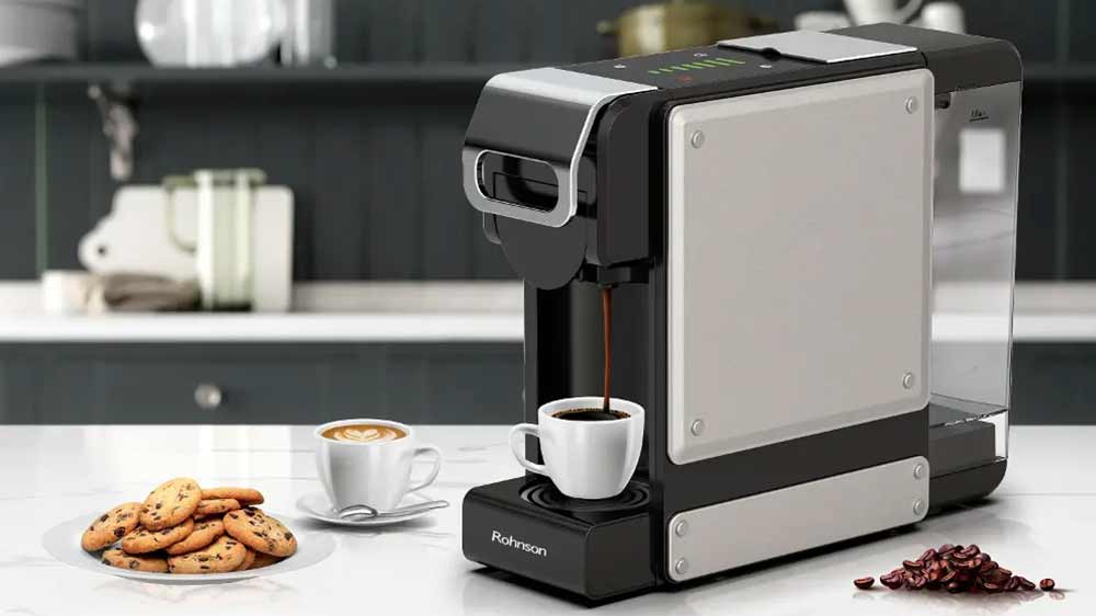Kávovar na kapsle Rohnson R-98044 v kuchyni vedle talířku se sušenkami připravuje šálek kávy_04