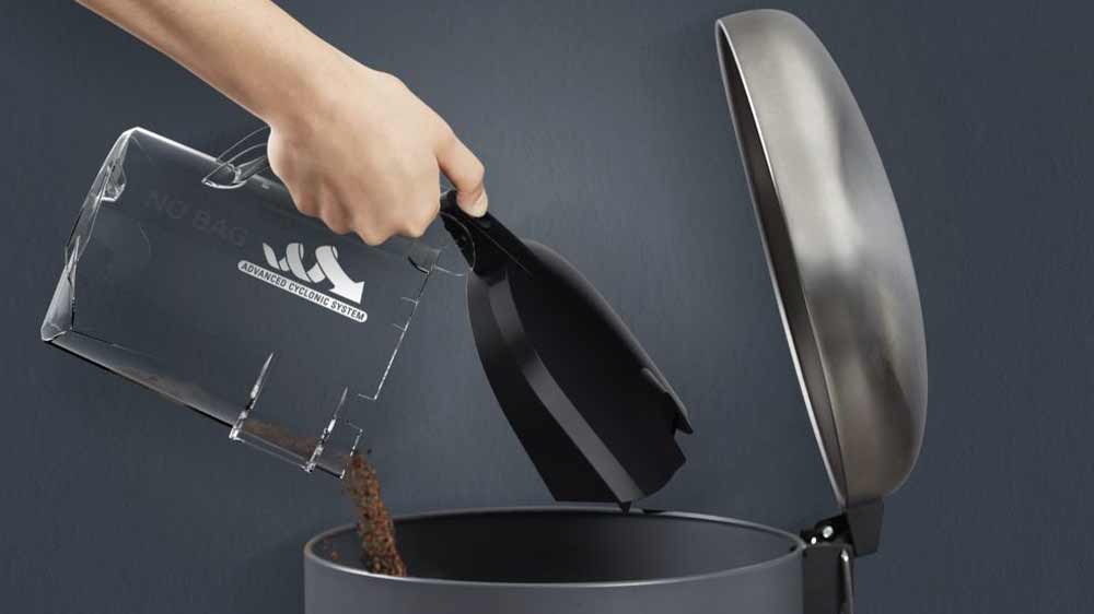 Ženská ruka vysypávajúca nádobu na prach vysávača Rowenta RO3725EA do odpadkového koša_03