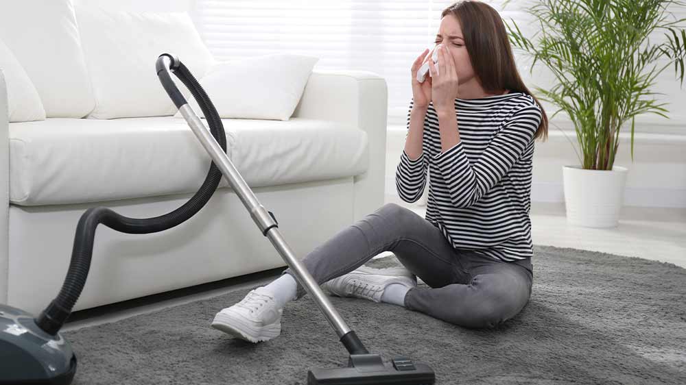 Žena trpiaca alergiou smrká počas vysávania_04