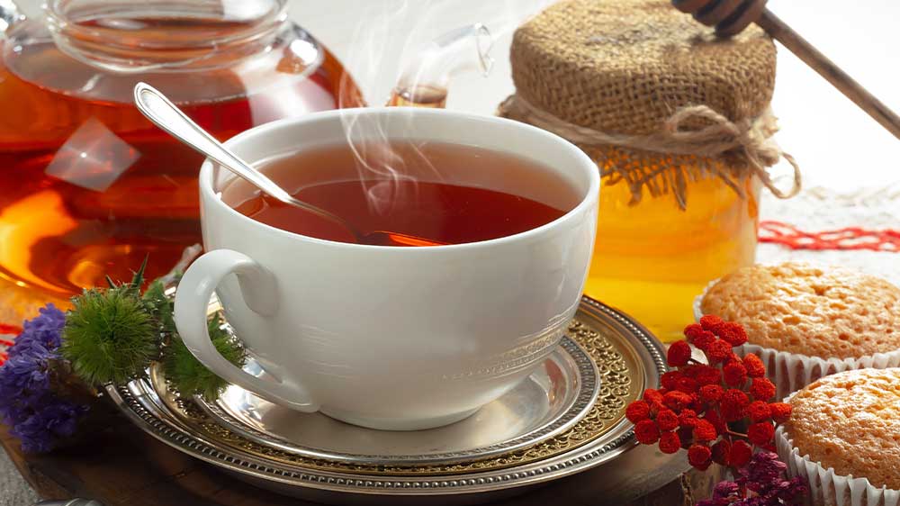 Horký čaj v hrnečku s medem a jídlem kolem_03