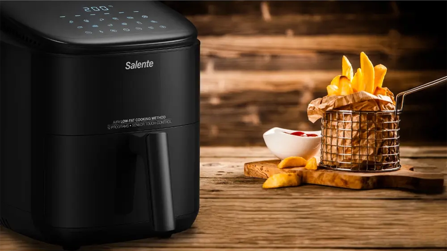 Horkovzdušná fritéza Salente AirFit 4v1 a vedle hranolky na prkénku