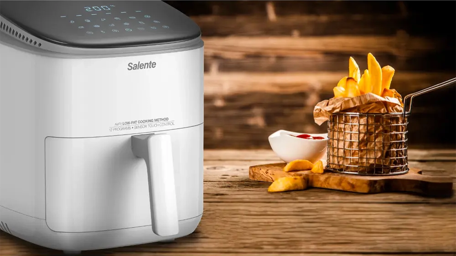 Horkovzdušná fritéza Salente AirFit 4v1 a vedle hranolky na prkénku