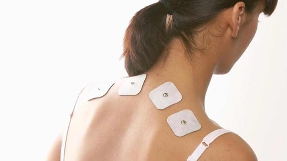 Žena s elektrodami svalového a nervového elektrostimulátoru Sanitas SEM 43 na zádech_03