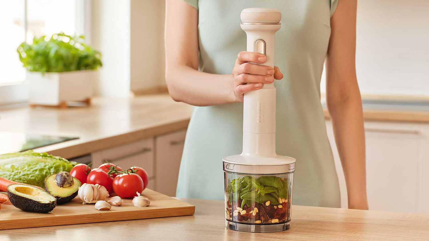 Žena pripravuje ingrediencie v n&aacute;dobe sek&aacute;čika Sencor SHBXD 0004
