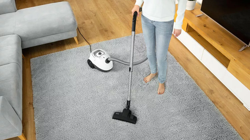 Žena vysává koberec vysavačem sencor SVC 5500WH_05