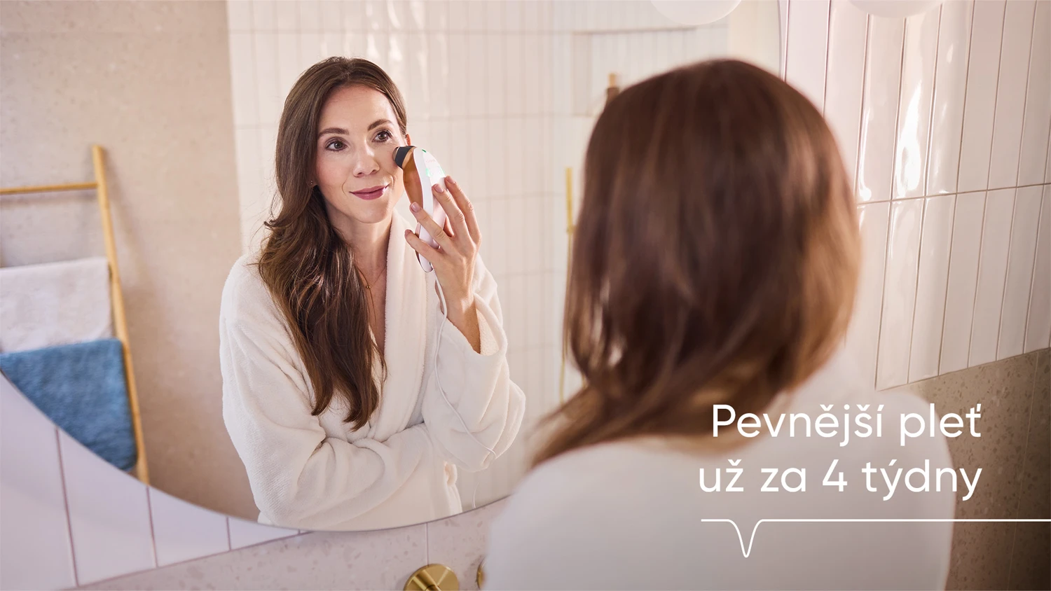 Slečna před zrcadlem v koupelně používá RF zařízení Sensica na tvář