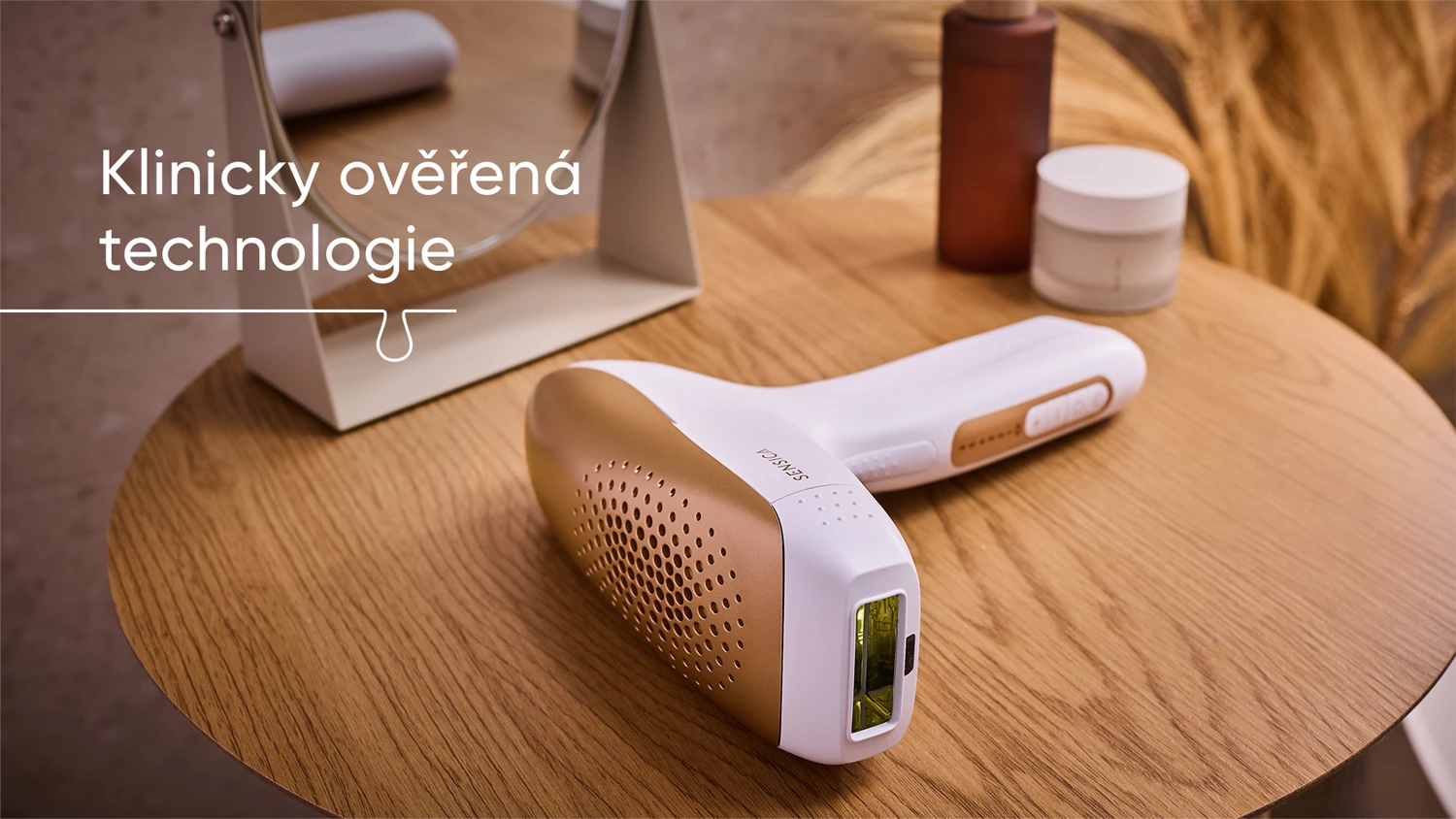 IPL epil&aacute;tor Sensica Sensilight&trade; Pro lež&iacute; na stolku vedle zrc&aacute;tka a kosmetick&yacute;ch potřeb