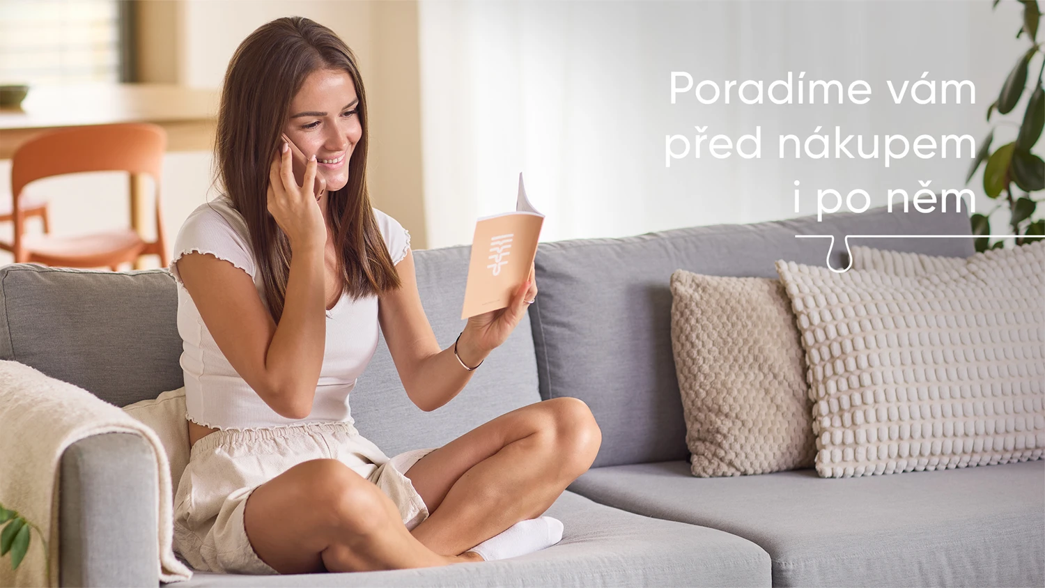 Slečna sed&iacute; na pohovce v ob&yacute;v&aacute;ku, telefonuje a v ruce drž&iacute; manu&aacute;l
