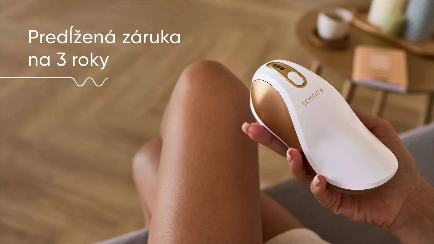 Slečna sedí na pohovke v obývačke a v ruke drží RF zariadenie Sensica