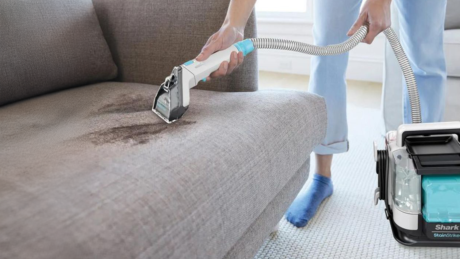 Žena čistiacu pohovku pomocou tepovača Shark PX200EUT