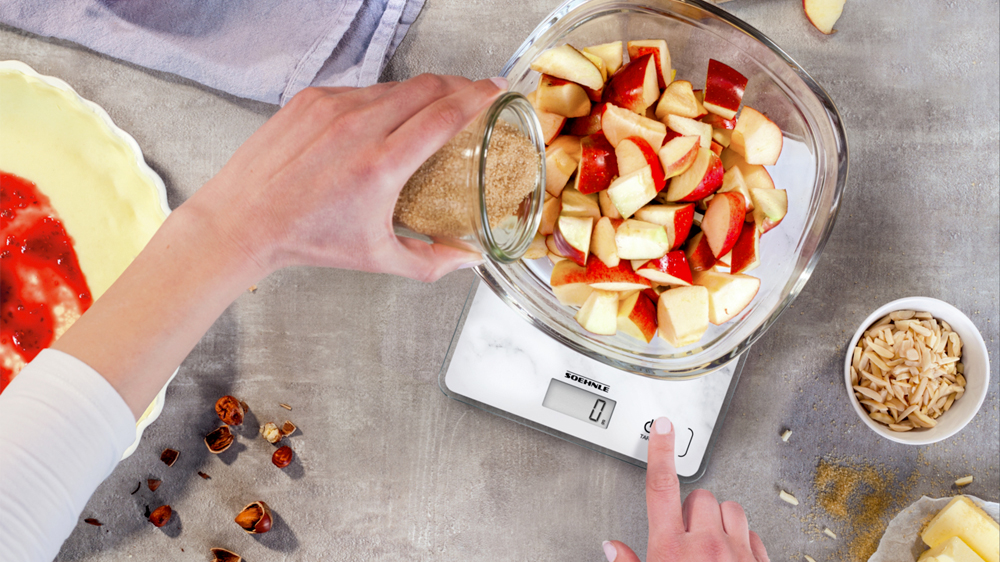 Člověk vážící jablka na digitální kuchyňské váze Soehnle Page Compact 300_02