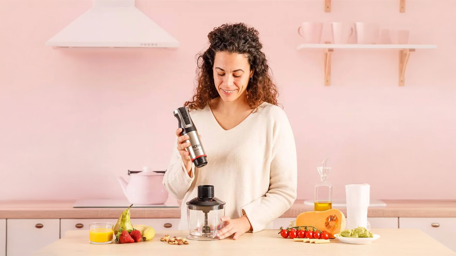 Žena v kuchyní používá sekáček k tyčovému mixéru Solac