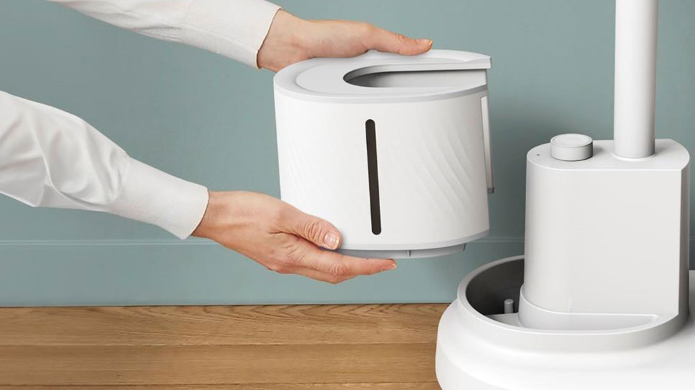Člověk vyndávající zásobník na vodu stojanového napařovače oděvů Tefal IT3280E1 Origin Home v místnosti_04