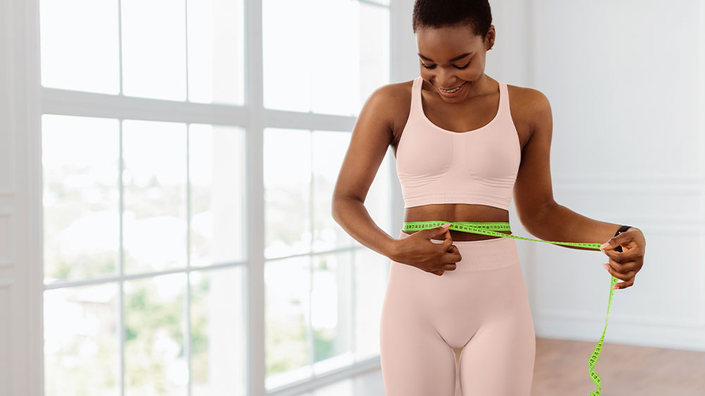Mladá štíhlá žena si měří obvod pasu_02
