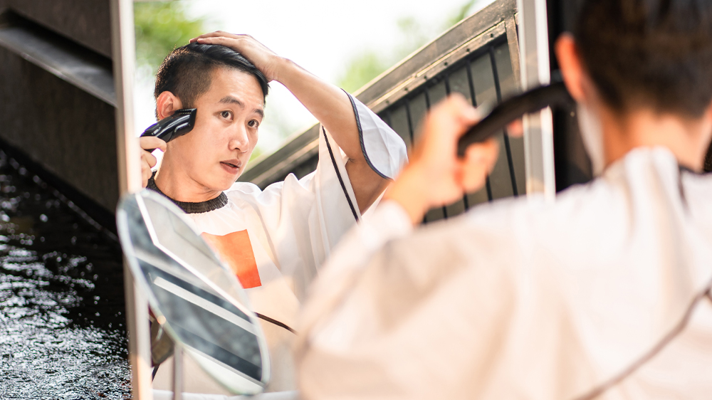 Muž stříhající si vlasy před zrcadlem_03