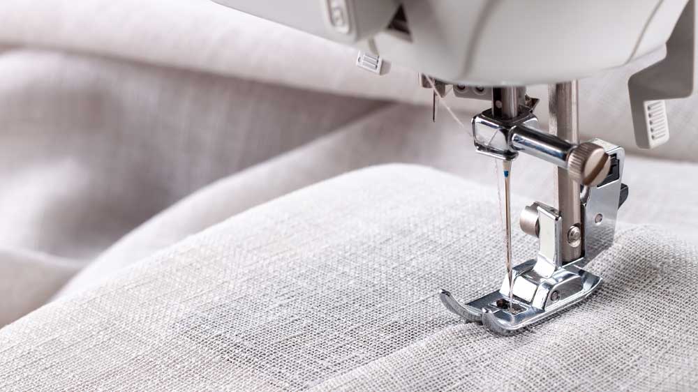 Detail na šicí jehlu a patku při šití látky_02
