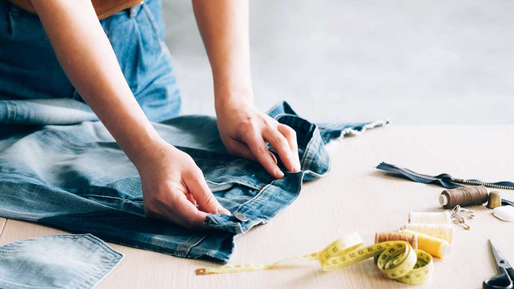 Žena pripravujúca si džínsy na prešitie_02